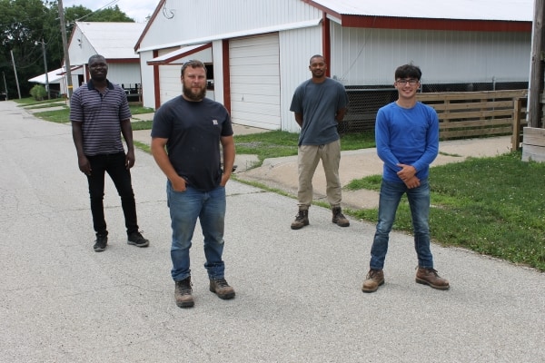 4 people standing outside spaced 6 feet apart