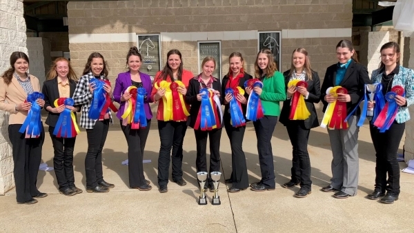 11 people standing with ribbons & trophies