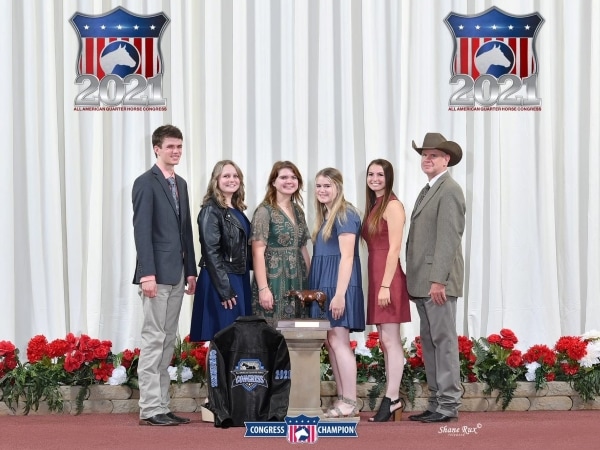 6 people standing with trophy and award jacket