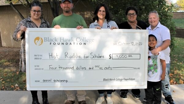 6 people standing outdoors with oversized check