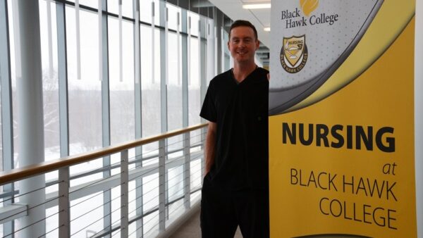 student posing near nursing sign