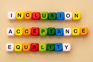 colorful wooden blocks that spell out inclusion acceptance equality