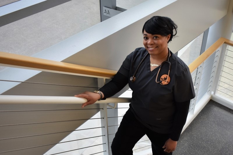 woman in nursing scrubs walking up staircase