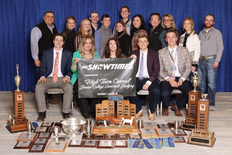 17 people with trophies, ribbons & plaques