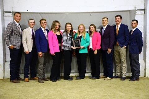 10 people lined up with plaque & smiling at camera