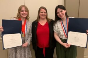 3 people standing, holding certificates and smiling