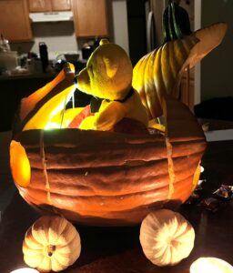 smiling carved pumpkin with wheels & teddy bear