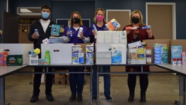 4 people standing with kitchen & toiletry items