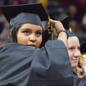 Student adjusting the tassel on her graduation cap