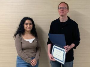 Two people smiling and holding certificate