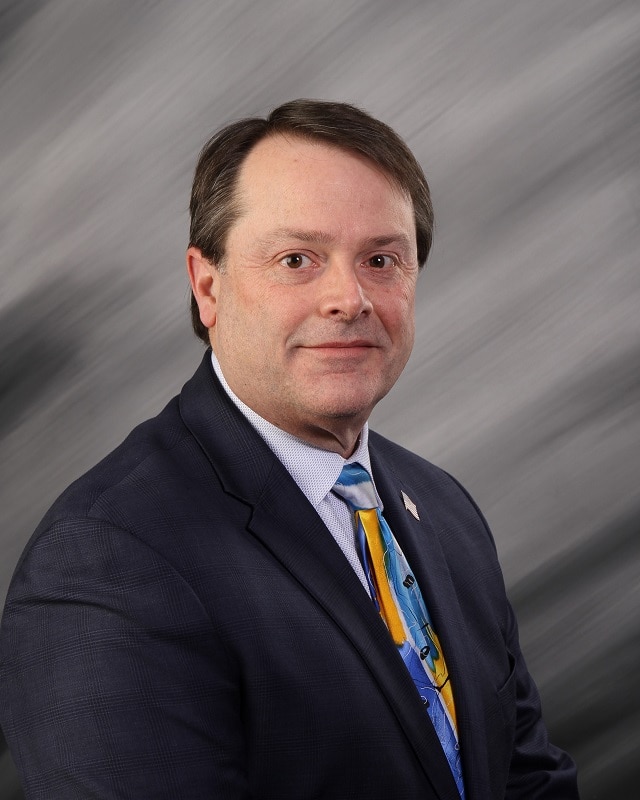 head and shoulders of man wearing suit and tie