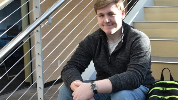 male student sitting on a staircase