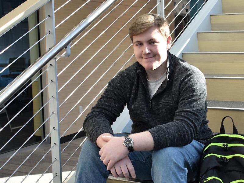 male student sitting on a staircase