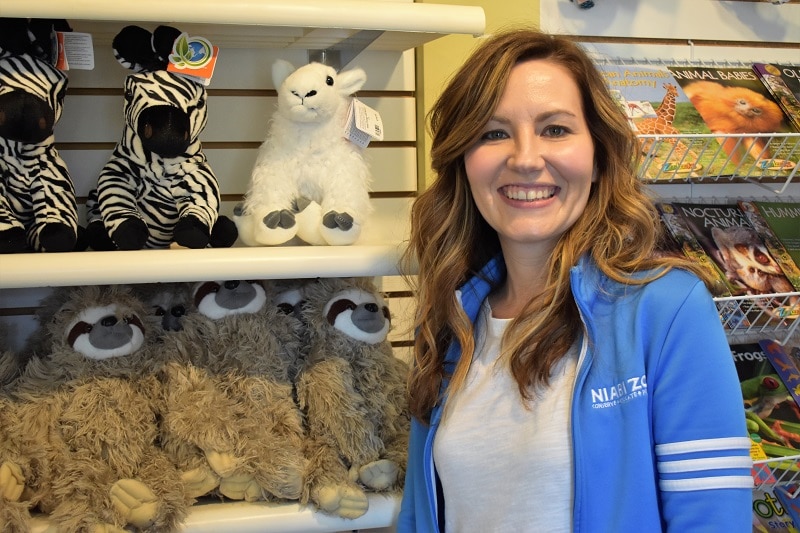 woman standing in front of a display of stuffed animals and books