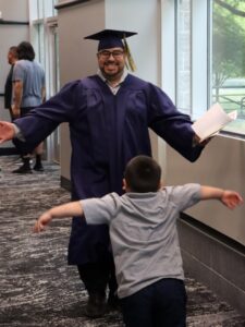 Grad Sergio Ochoa-Valazquez with arms open as son runs up to him