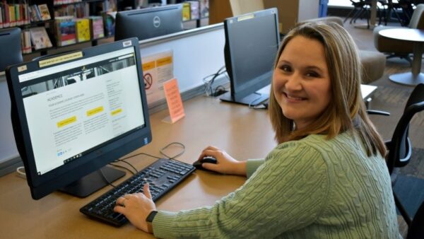 sitting female student using a computer in a library