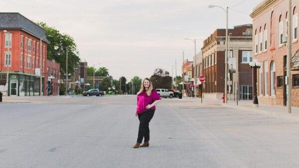 woman stands in the street in downtown Aledo