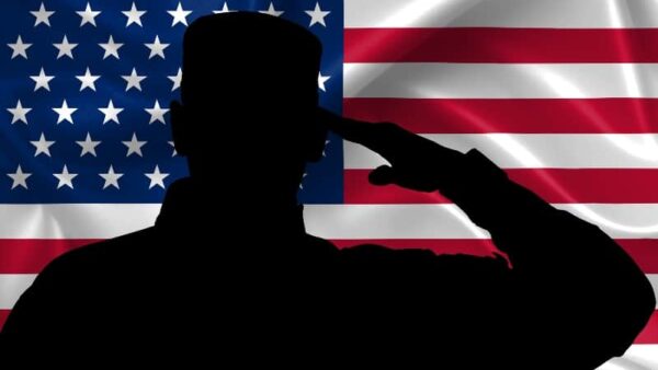 silhouette of soldier saluting with U.S. flag in background