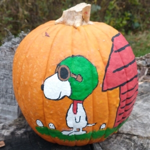 Snoopy dressed as World War II flying ace and his doghouse painted on a pumpkin