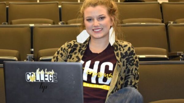 female student sits with laptop