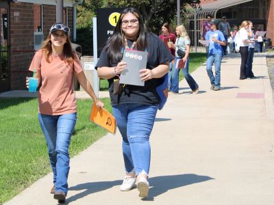 smiling students walking outdoors at East Campus