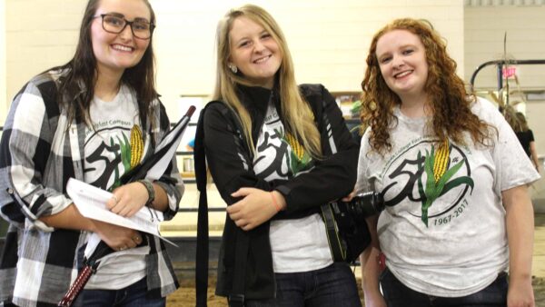 three smiling female students wearing East Campus 50th T-shirts