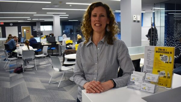 BHC employee standing in Tutoring Center with sessions going on in background