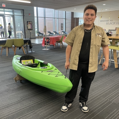 student with kayak in upper lobby of Building 1