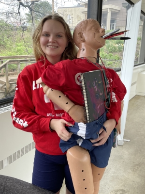 student holding mannequin with school supplies