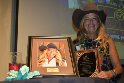 smiling woman with plaque & framed photo