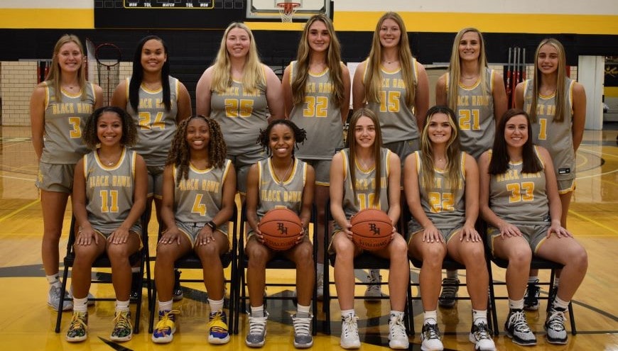 7 women's basketball players standing and 6 players seated