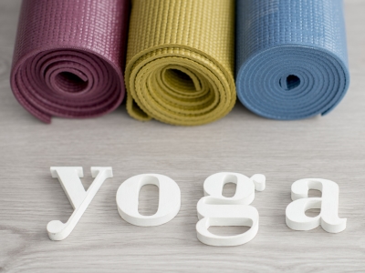 3 rolled up yoga mats and the word yoga