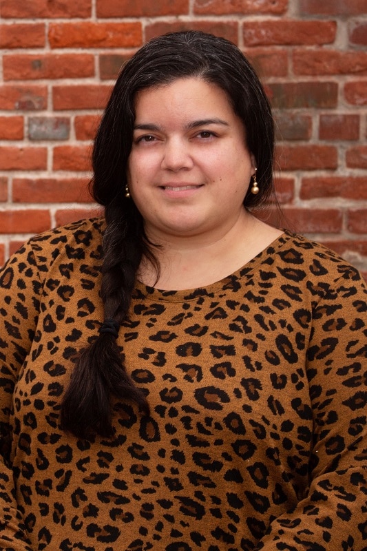 smiling woman in front of a brick wall